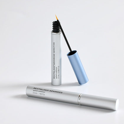 Eyelash serum with applicator on a white background